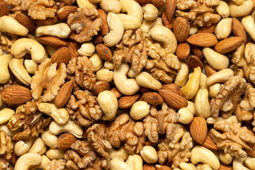Assorted nuts background. Walnuts, almonds and cashews mixed together. - obrazy, fototapety, plakaty