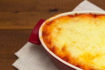 Shepherd's pie, traditional dish with minced meat and mashed potato on wooden table