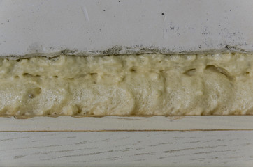 Foam between the concrete wall and the wooden frame
