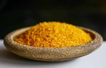 Yellow corn grits on wooden plate.