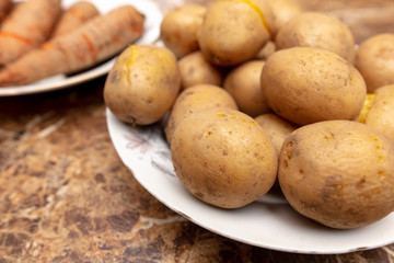 Boiled potatoes and carrots in a plate on the table
