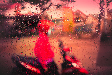 A rider waiting at a traffic signal in rain