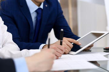 Businessman using laptop at meeting, closeup of hands. Business operations concept