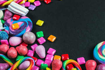 chewing gum, candy, chewing marmalade, lollipops and other sweets on black background