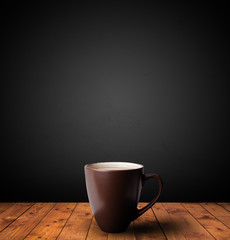 Cup of drink on wooden table with dark background
