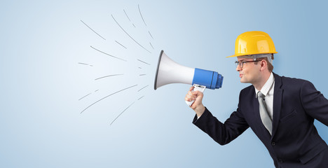 Fototapeta premium Young architect constructor yelling with megaphone and copyspace 