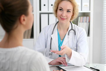 Happy blonde female doctor and patient discussing medical examination results. Medicine, healthcare and help concept