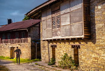 Man walking across a street in an ancient village 