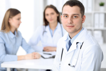 Medicine doctor standing and  smiling on the background with patient in the bed