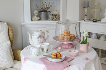 Tischdekoration mit Muffins und Porzellan in Weiß und Rosa