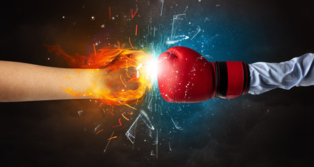 Two hands fighting and breaking glass into small pieces with fire and water concept
