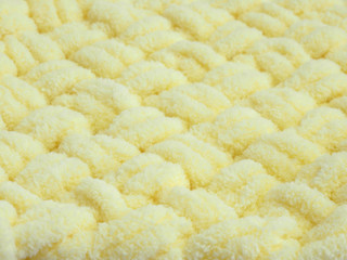 .abstract background of knitted yellow plush blanket