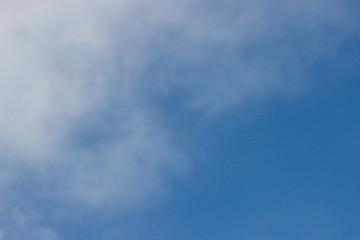 Blue sky. Blue sky with light clouds. From the blue sky it is snowing. Winter bright blue sky