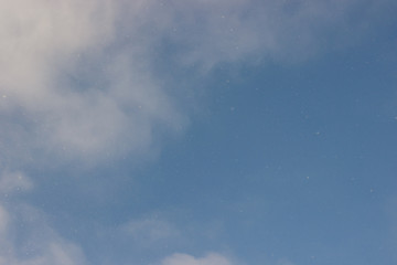 Blue sky. Blue sky with light clouds. From the blue sky it is snowing. Winter bright blue sky