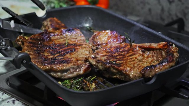 Cooking beef on grill frying pan on gas oven