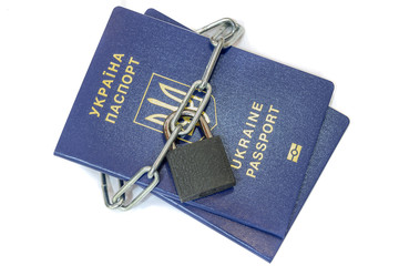 Blue ukrainian passports pair wrapped in a chain with a golden lock on a white background