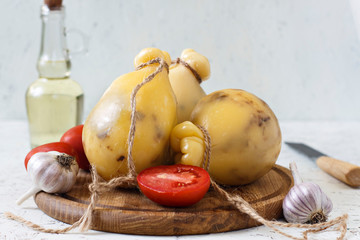 Cheese Caciocavallo, tomatoes, garlic, olive oil on a white background. Cheese pear