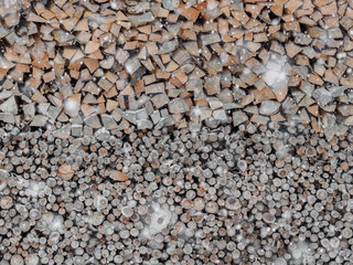 Neatly stacked firewood in snowfall in Austria
