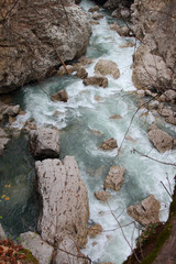 The mountain river flows among the boulders in the gorge.