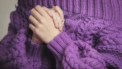 Closeup of beautiful woman in knitted, purple oversize sweater on white background