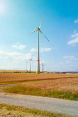 Eco power. Wind turbines generating electricity. Wind turbines and agricultural fields on a summer day - Energy Production with clean and Renewable Energy