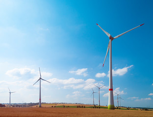 Eco power. Wind turbines generating electricity. Wind turbines and agricultural fields on a summer...