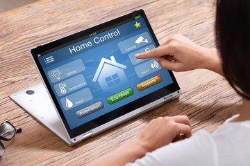 Person Using Home Control System On Digital Laptop