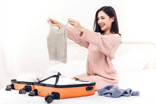 Woman packing a suitcase luggage and backpack for travel at home.Holiday vacation concept
