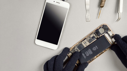 Technician or engineer disassembling components broken smartphone for repair or replace new...