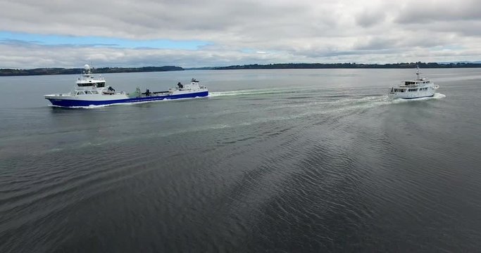 Aerial view with drone of a wellboat sailing through the archipelago of Chilo&eacute;