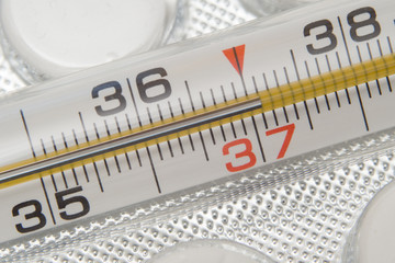 Medical thermometer and pills on white background. Medicines and medical thermometer