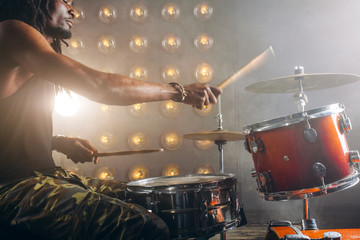 talented man playing drums on stage. close up side view photo. copy space. hobby, lifestyle