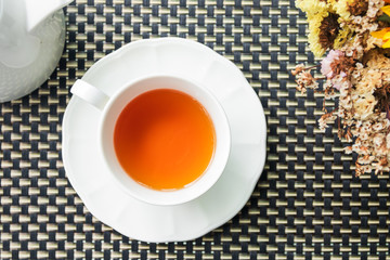 Porcelain cup of earl grey tea on table with soft sunlight in afternoon. Top view