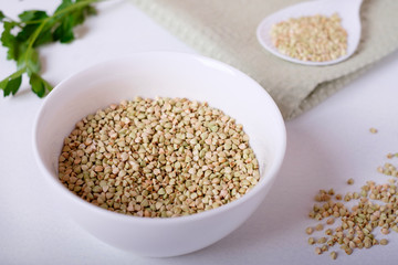raw green buckwheat on a white background