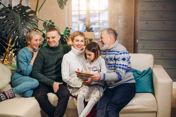 kind pleasant family sharing memories while sitting on white couch.