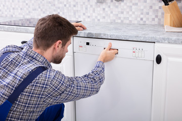 Obraz premium Man Pressing Button Of Dishwasher