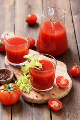 Tomato juice in glass with celery, cherry tomato  on dark background.