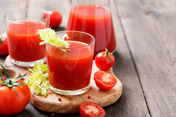 Tomato juice in glass with celery, cherry tomato  on dark background.