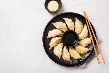 Plate of Japanese gyoza, dumplings snack , with soy sauce .