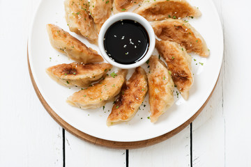 Plate of Japanese gyoza, dumplings snack , with soy sauce .
