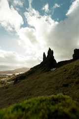 Old Man of Storr as seen from a higher viewpoint with dramatic sky and bright sun (Isle of Skye, Scotland, United Kingdom)
