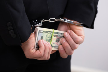 An Arrested Person Holding Dollars Bill