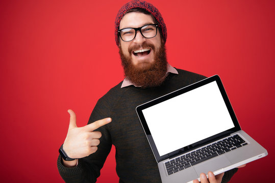 Excited Happy Bearded Man Pointing Finger At Blank Screen Laptop