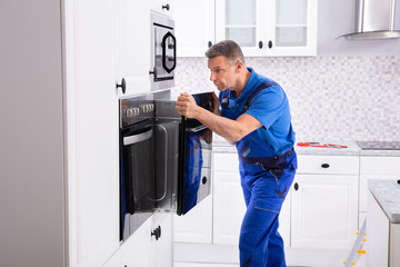 Technician In Overall Installing Oven