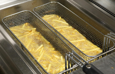 potato chicps frying in a deep fryer