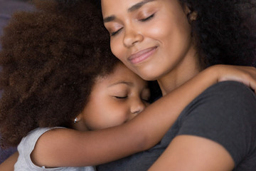 Loving single black mother hugs cute daughter feel tenderness connection, happy african mum...