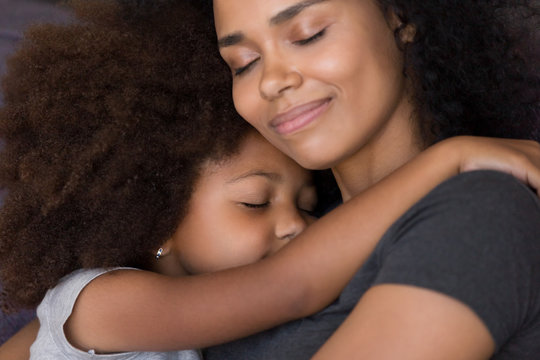 Loving single black mother hugs cute daughter feel tenderness connection, happy african mum caressing embracing little girl, mommy kid cuddle, warm relationships, child custody, foster care concept