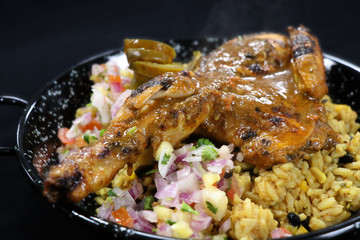 spice roasted whole baby chicken with flavored rice in a serving dish