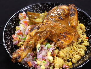 spice roasted whole baby chicken with flavored rice in a serving dish