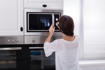 Fototapeta na wymiar Woman Using Microwave Oven